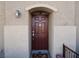 Close-up of the front door, featuring a solid wood door with an arched entryway and decorative hardware at 7665 Calico Fields St, Las Vegas, NV 89149
