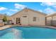 Backyard pool with desert landscaping, home exterior, and outdoor seating and grill at 8468 W Gilmore Ave, Las Vegas, NV 89129