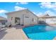 Backyard pool with patio, desert landscaping, home exterior, and outdoor seating at 8468 W Gilmore Ave, Las Vegas, NV 89129