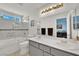 Bright bathroom features a shower-tub combo and double sinks set in gray cabinets at 8468 W Gilmore Ave, Las Vegas, NV 89129