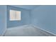 A minimalist bedroom features light blue walls, carpet, and a window with blinds at 8468 W Gilmore Ave, Las Vegas, NV 89129