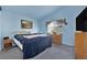 Comfortable bedroom with blue walls, carpet, and window providing natural light at 8468 W Gilmore Ave, Las Vegas, NV 89129
