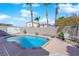 Backyard pool with palm trees, desert landscaping, privacy wall, and outdoor seating at 8468 W Gilmore Ave, Las Vegas, NV 89129