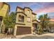 Two-story home with a two-car garage and a cozy front porch, enhanced by lush landscaping at 8932 Jaquita Ave, Las Vegas, NV 89149