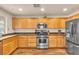 Well-lit kitchen with stainless steel appliances, wood cabinets and beautiful hardwood floors at 8932 Jaquita Ave, Las Vegas, NV 89149