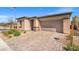Paver driveway leading to an attached two-car garage, surrounded by desert landscaping at 10186 Zeta Tucana St, Las Vegas, NV 89143