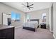 Bright main bedroom with a ceiling fan, plush carpeting, and ample natural light at 10186 Zeta Tucana St, Las Vegas, NV 89143