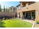 Backyard featuring artificial grass, a patio with comfortable seating, and a hot tub at 12381 Liberty Beacon Ave, Las Vegas, NV 89138