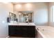 Clean bathroom featuring dual sink vanity, large mirror and tub at 12381 Liberty Beacon Ave, Las Vegas, NV 89138