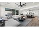 Bright living room featuring sectional sofa, ceiling fan, and access to the outdoor space at 12452 Lincoln Creek Ave, Las Vegas, NV 89138