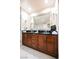 Vanity with dark wood cabinets, double sinks, countertop, and large mirror with sconces at 145 E Harmon Ave # 2007, Las Vegas, NV 89109