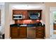 Modern kitchenette featuring dark wood cabinets, a stainless steel microwave and refrigerator, and a black countertop at 145 E Harmon Ave # 2007, Las Vegas, NV 89109