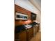 Modern kitchenette with wood cabinets, black countertops, stainless steel appliances, and a mini-fridge at 145 E Harmon Ave # 2007, Las Vegas, NV 89109