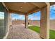 Covered patio with brick pavers, artificial turf, and a block wall at 1485 Sound Ln, North Las Vegas, NV 89031