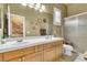 Bathroom featuring a double sink vanity, decorative mirrors, and glass enclosed shower at 181 Cliff Valley Dr, Las Vegas, NV 89148