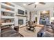 Inviting living room with a fireplace, built-in shelving, a ceiling fan, and plush leather seating at 181 Cliff Valley Dr, Las Vegas, NV 89148