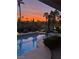 Inviting pool area with sunset view, featuring lounge chairs and lush landscaping, perfect for relaxation and outdoor living at 181 Cliff Valley Dr, Las Vegas, NV 89148