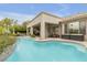 A sparkling pool with waterfall feature, mature landscaping, and covered patio seating at 181 Cliff Valley Dr, Las Vegas, NV 89148