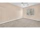 Bright bedroom with neutral carpet, ceiling fan, and window overlooking the exterior at 1923 Grey Eagle St, Henderson, NV 89074