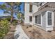 Exterior view of a two story condo featuring desert landscaping, and a charming pathway with lush green trees at 2325 Windmill Pkwy # 1313, Henderson, NV 89074