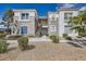 Exterior of a well-maintained condo with stucco walls, desert landscaping and stairs leading to upper units at 2325 Windmill Pkwy # 1313, Henderson, NV 89074