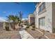 Beautiful condominium exterior showcasing walkway, stucco facade, and desert landscaping under a clear blue sky at 2325 Windmill Pkwy # 1313, Henderson, NV 89074