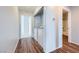 Well-lit hallway with wood floors, a laundry closet featuring a washer/dryer, and an adjacent bathroom with a tub at 2325 Windmill Pkwy # 1313, Henderson, NV 89074