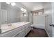 Bright bathroom featuring a double sink vanity with white cabinets, tub and shower combo, and dark wood flooring at 2528 Furnace Creek Ave, Henderson, NV 89074
