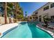Stunning pool with a jacuzzi, surrounded by lush greenery and a covered patio with spiral staircase at 2528 Furnace Creek Ave, Henderson, NV 89074