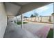 Covered patio area with concrete flooring, gravel landscaping, and fenced yard at 2549 Pine Creek Rd, Las Vegas, NV 89115