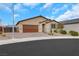 Single-story home with a brick driveway, desert landscaping, and a neutral colored facade and a two car garage at 3018 Carothers Ct, North Las Vegas, NV 89032