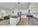 Bright, open kitchen features a kitchen island, stainless steel appliances, white cabinetry and wood-look tile floors at 3018 Carothers Ct, North Las Vegas, NV 89032