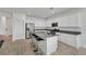 Well-lit kitchen showcasing an island with barstool seating, stainless appliances, and white cabinets at 3018 Carothers Ct, North Las Vegas, NV 89032