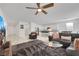 Open-concept living area with a large gray sofa, modern furniture, and view into the kitchen and dining space at 3018 Carothers Ct, North Las Vegas, NV 89032