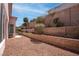 Desert landscaped backyard featuring a low brick wall and lush trees at 3025 Treesdale Dr, Las Vegas, NV 89134