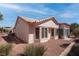 Cozy backyard featuring desert landscaping, a tile roof, and an exterior stucco wall with white trim windows at 3025 Treesdale Dr, Las Vegas, NV 89134