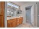 Bathroom featuring double sinks, a large mirror with lighting, and a glass-enclosed shower at 3025 Treesdale Dr, Las Vegas, NV 89134