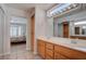 Bathroom featuring double sinks, a large mirror, and an open doorway to the bedroom at 3025 Treesdale Dr, Las Vegas, NV 89134