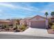 A single-story home with neutral tones, desert landscaping, and a concrete driveway at 3025 Treesdale Dr, Las Vegas, NV 89134