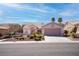 A bright single-story home featuring desert landscaping, a two-car garage, and a tile roof at 3025 Treesdale Dr, Las Vegas, NV 89134