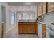 Open kitchen view with white appliances, wood cabinets, tile floors, and bay window breakfast nook at 3025 Treesdale Dr, Las Vegas, NV 89134