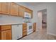 Functional kitchen featuring wood cabinetry, white appliances, and tile flooring at 3025 Treesdale Dr, Las Vegas, NV 89134