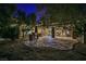 Backyard featuring an outdoor kitchen area, built-in grill, spacious stone patio, desert trees and plantings at 3163 Elk Clover St, Las Vegas, NV 89135