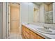 Bright bathroom featuring double sinks, wood cabinets, tile floor, and walk-in shower at 3163 Elk Clover St, Las Vegas, NV 89135