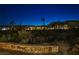 Twilight view of desert landscape with distant houses, palm trees, native foliage, and rock borders under a starlit sky at 3163 Elk Clover St, Las Vegas, NV 89135