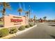 Private entrance to Red Rock Country Club, featuring lush greenery and clear blue skies at 3163 Elk Clover St, Las Vegas, NV 89135