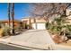 Well-maintained home exterior featuring a wide driveway, two-car garage, and mature desert landscaping at 3163 Elk Clover St, Las Vegas, NV 89135
