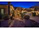 Elegant home exterior with an ornate entrance and landscaped front yard, enhanced by evening lighting at 3163 Elk Clover St, Las Vegas, NV 89135
