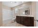 Well-lit bathroom features a double vanity, large mirror, and a separate tub and toilet at 3167 Biccari Ave, Henderson, NV 89044