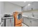 Well-equipped laundry room with gray cabinets, sink, and modern washer and dryer at 3221 Montecito Dr, Las Vegas, NV 89120